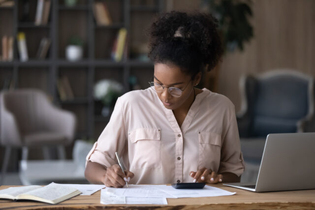 serious,african,american,woman,in,glasses,calculating,expenses,,using,calculator,